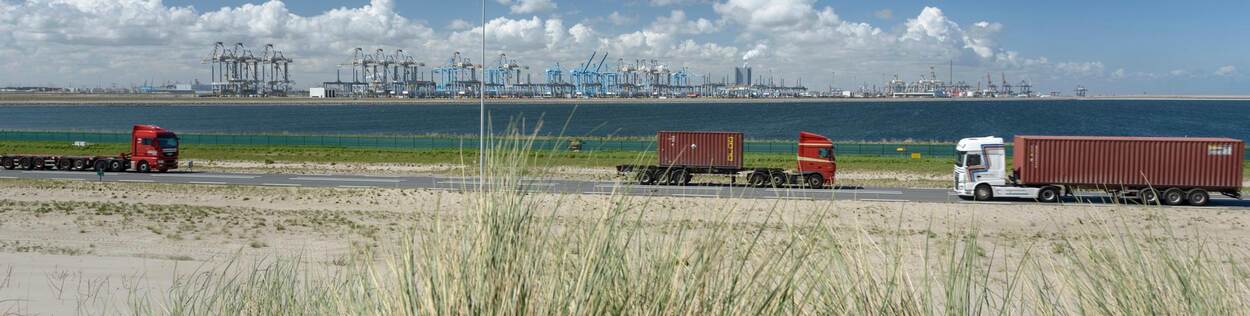 Vrachtwagens rijden op weg met op de achtergrond haventerminal