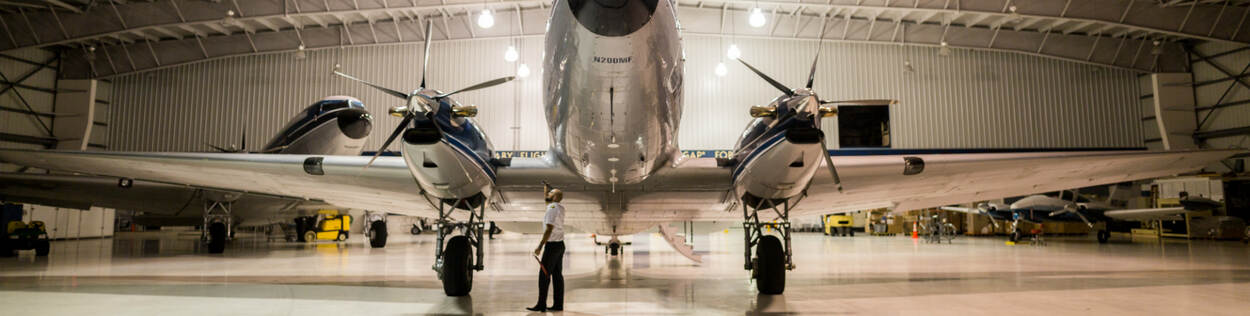 Rechtervoorkant van groot vliegtuig in hangar