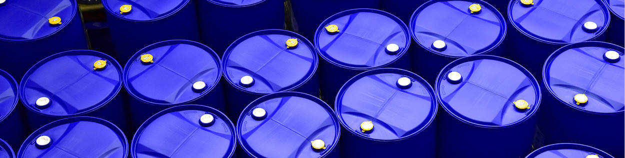 Diverse blauwe vaten, die worden gebruikt om vloeistof in te bewaren en te vervoeren, staan naast elkaar.