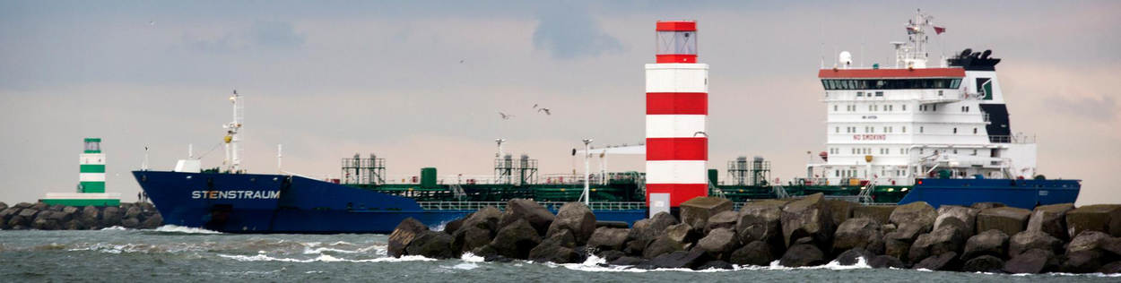 Een zeeschip vaart een haven binnen.